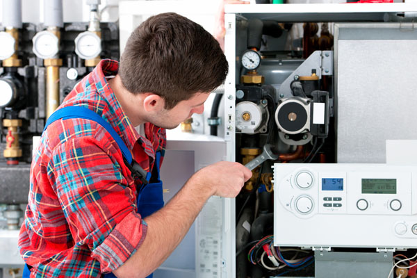HVAC technician inspecting and repairing boiler controls in Windsor