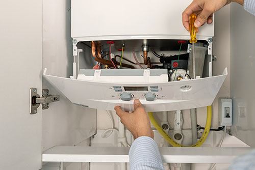 HVAC technician repairing an indoor boiler in Windsor