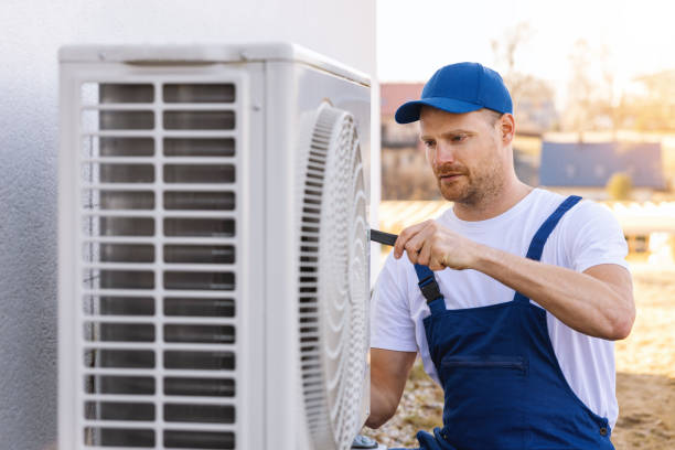 HVAC technician servicing an outdoor air conditioning unit in Windsor