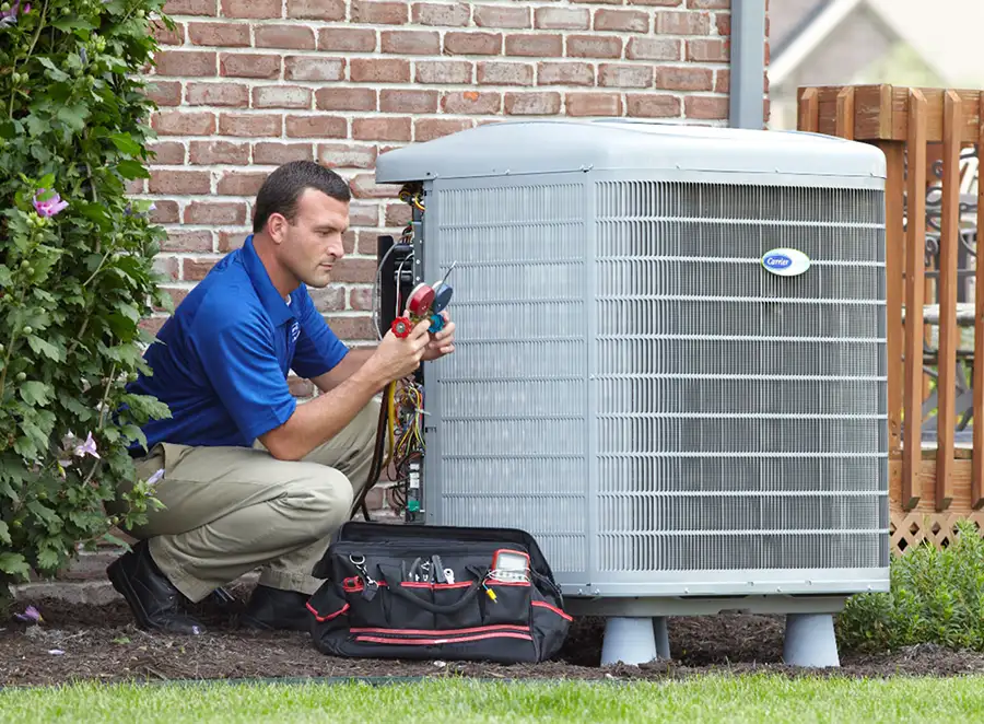 HVAC technician inspecting an outdoor air conditioning unit in Windsor