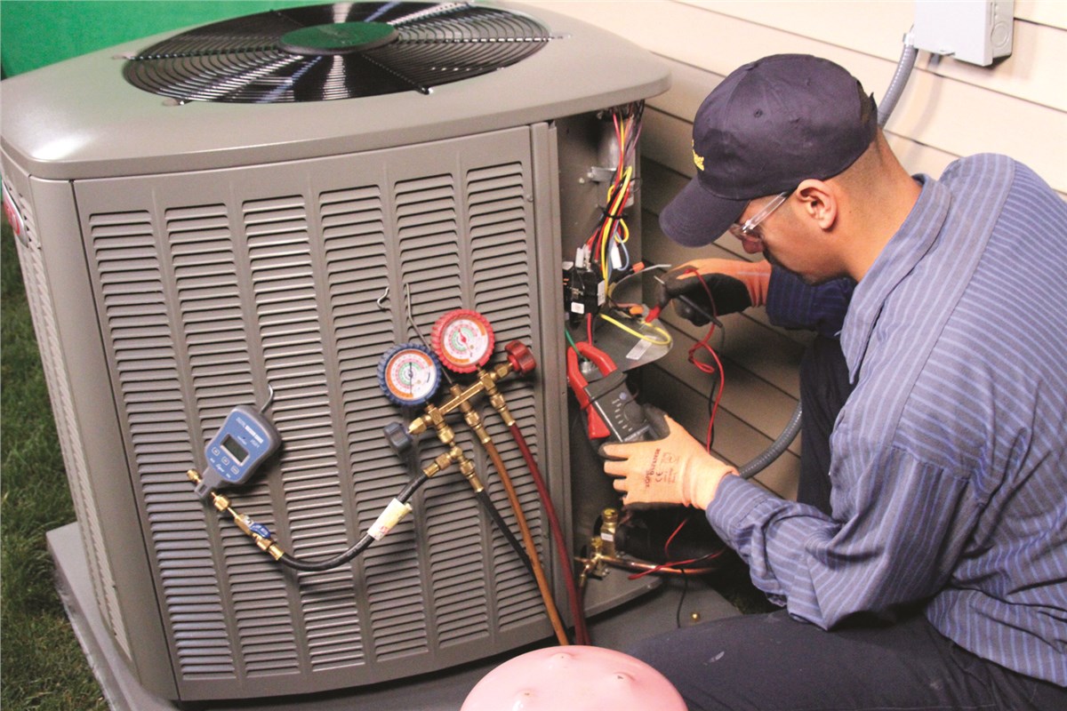 HVAC technician testing an outdoor air conditioning unit in Windsor