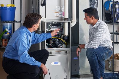 65df8c11f3e4c468cbd351a5_furnace repair vs replacement – Copy HVAC technician explaining furnace repair and maintenance to a homeowner in Windsor, CO