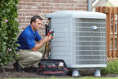 design-air-heating-and-air-conditioning-decatur-il-05 – Copy HVAC technician inspecting an outdoor air conditioning unit in Windsor, CO