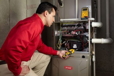 furnace repair Heating and air conditioning technician servicing an indoor furnace in Windsor, CO